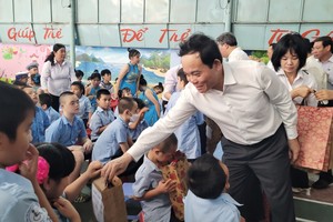 越南政府副总理陈流光给孩子们送上慰问品。（图片来源：庆和报）