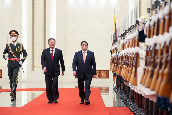 越南政府总理范明正和中国国务院总理李强检阅仪仗队。（图片来源：VGP）