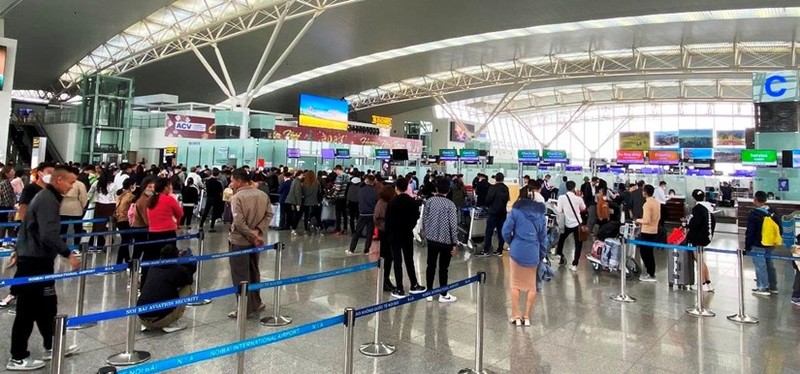 附图：游客在内排国际机场办理登机手续。