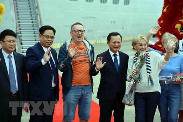 广宁省人民委员会代主席高祥辉（右三）向外国游客送鲜花。（图片来源：越通社）