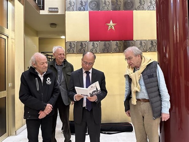 越南驻法国大使丁全胜阅读《巴黎圣母院塔尖上的越共旗帜》一书。（图片来源：越通社）