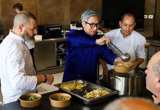 越南驻以色列大使李德忠与阿提里奥烹饪技工学校厨师共同做鸡肉河粉。（图片来源：越通社）