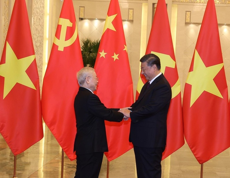 越共中央总书记阮富仲与中共中央总书记、中国国家主席习近平亲切握手。（图片来源：越通社）