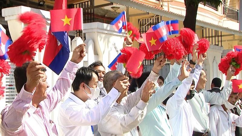 首都金边民众挥舞旗帜和鲜花，欢迎范明正总理和越南代表团。（图片来源：VGP）