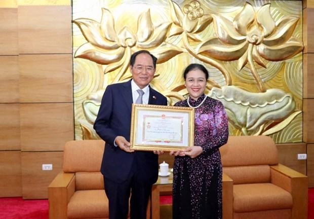 越南友好组织联合会主席阮芳娥向韩国驻越大使朴能运授予“致力于各民族间和平与友谊” 纪念章。