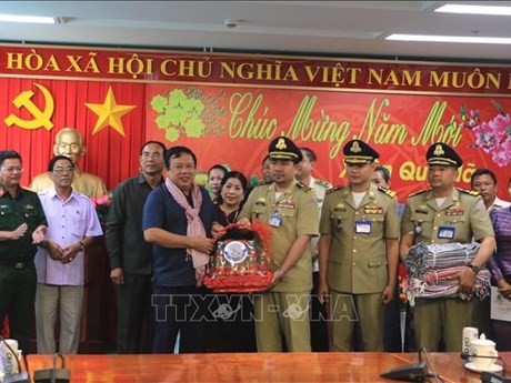 永隆省人民委员会副主席阮文烈接受由柬埔寨磅士卑省赠送的礼物。（图片来源：越通社）
