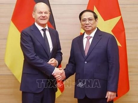 越南政府总理范明正与德国总理朔尔茨握手。