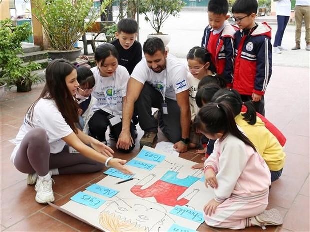 Heroes for Life组织的志愿者和沙坝市学生们一起玩游戏。
