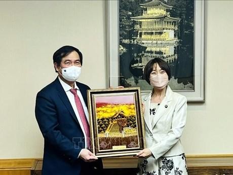 越共中央宣教部副部长潘春水（左）向日本共产党副主席田室智子赠送纪念品。