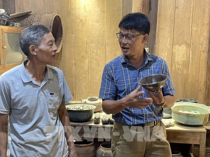 阮海兴先生（右）介绍自己收集的古物。