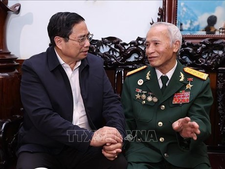政府总理范明正（左）与人民武装力量英雄邓非赏亲切交谈。