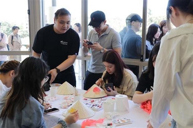 越南文化节上的给斗笠上妆活动吸引众多学生参加。（图片来源：越通社）