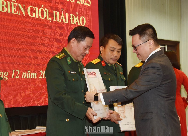 《人民报》社总编辑黎国明向战士们赠送春节特刊。