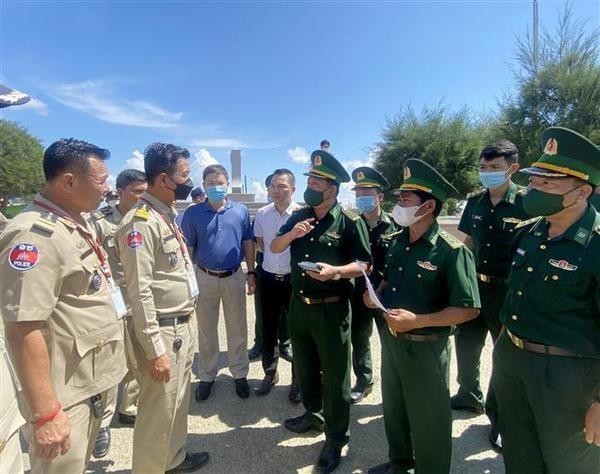 静边国际口岸边防哨所干部与柬埔寨职能力量就接收26名越南公民的手续进行交谈。（图片来源：越通社）