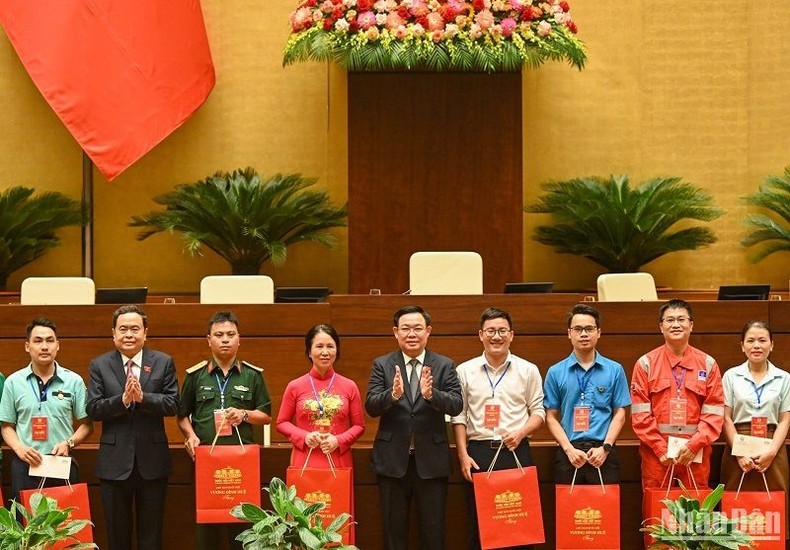 国会主席王廷惠和越南劳动总联合会主席阮廷康向取得成绩优异的工会会员和贫困劳动者赠送礼品。