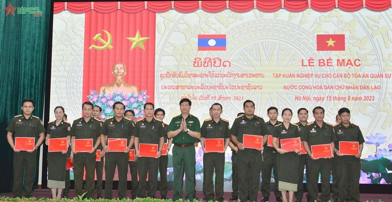 黄友贵大校向老挝学员颁发结业证书。（图片来源：《人民军队报》）