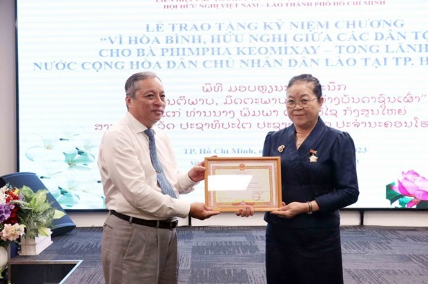 杜越河先生向老挝驻胡志明市总领事乔米赛授予纪念章。（图片来源：越通社）