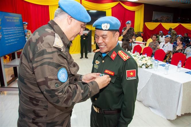 联南苏团警察副司令穆拉特·伊西克向黎国辉大校佩戴联合国“和平勋章”。（图片来源：越通社）