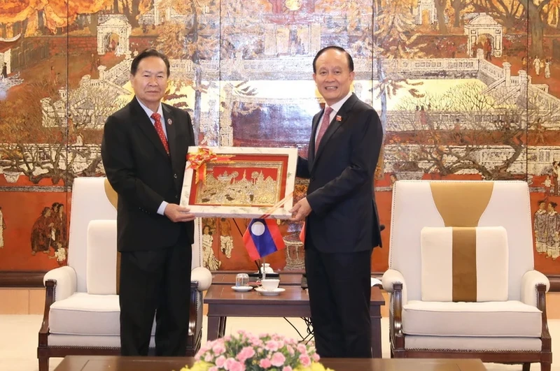 老挝国会副主席夏伦·亚保和向河内市人民议会主席阮玉俊赠送纪念品。