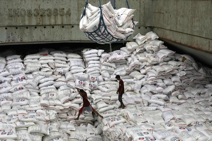 菲律宾塔克洛班市一个仓库的工人们搬运大米。