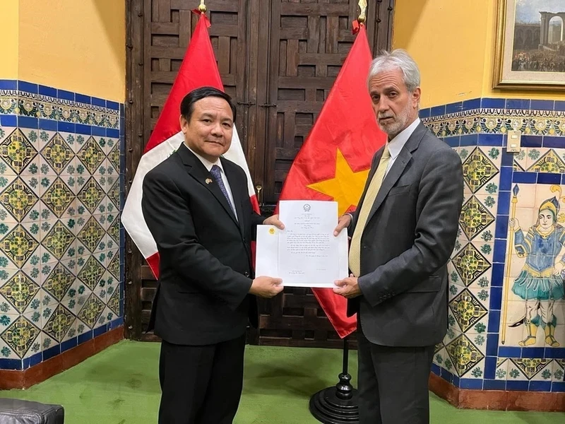 越南驻秘鲁大使裴文毅向秘鲁外交部礼宾局局长递交委任书副本。（图片来源：越通社）