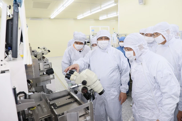 越南政府总理范明正访问半导体公司Hana Micro Vina的生产线。（图片来源：越通社）