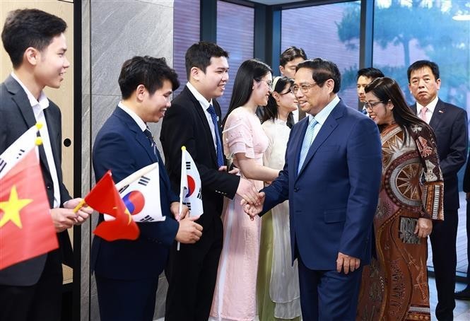 越南政府总理范明政和夫人与大使馆工作人员和侨胞们亲切握手。