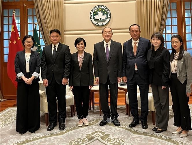 越南驻香港和澳门总领事黎德幸（左）与中国澳门特别行政区行政长官贺一诚和代表们合影。（图片来源：越通社）