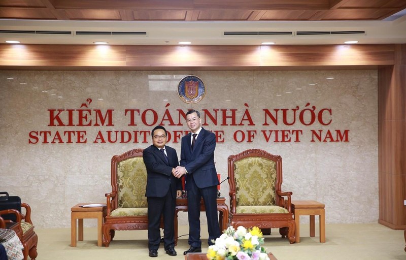 越南国家审计署副审计长吴文俊（右）与老挝国家审计署审计长亲切握手。（图片来源：越通社）