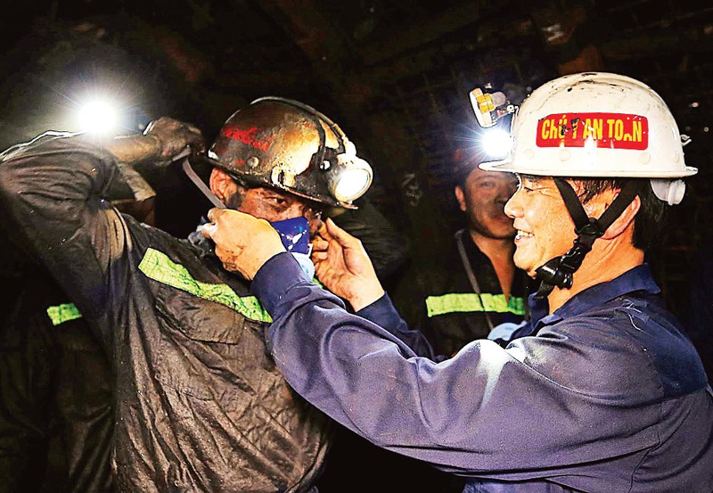 越南煤炭矿产工业集团工会主席黎青春向南亩煤炭公司员工赠送防尘口罩。（国姜摄）