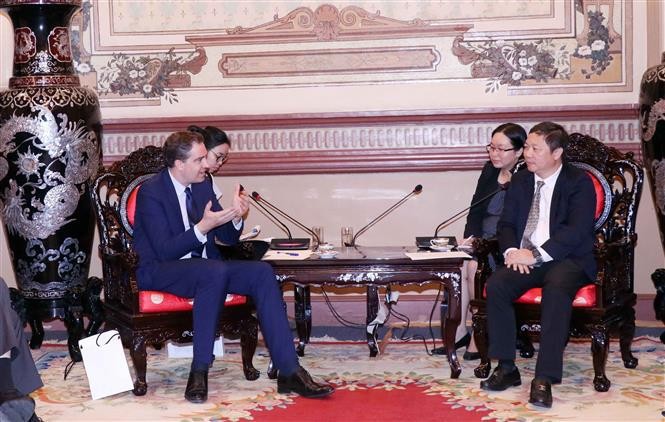 胡志明市人民委员会副主席杨英德（右一）与法国外贸事务部长奥利维尔·白赫特交谈。（图片来源：越通社）