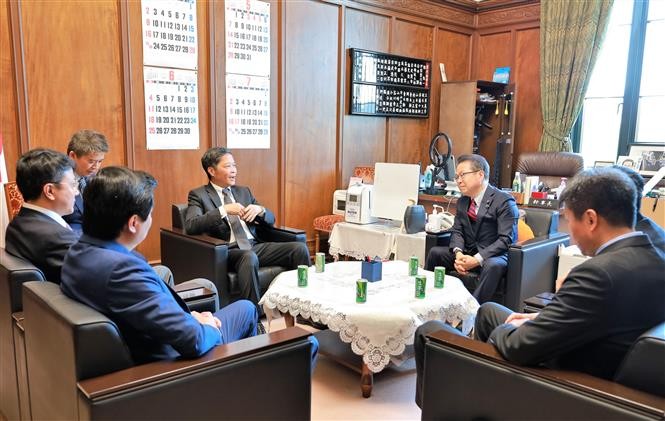 越共中央经济部部长陈俊英会见日本执政党自由民主党干事长茂木敏充。（图片来源：越通社）
