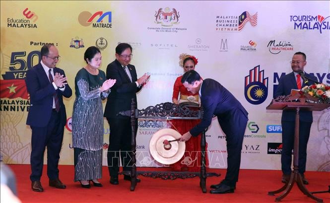胡志明市人民委员会副主席裴春强在马来西亚展上进行开展敲锣仪式。（图片来源：越通社）