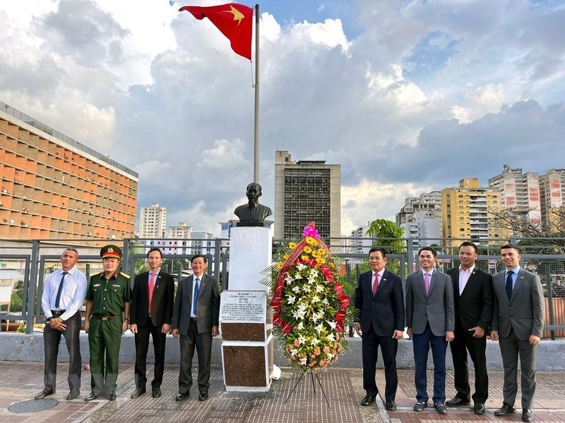 与会代表在胡志明主席雕像前合影留念。（图片来源：越通社）