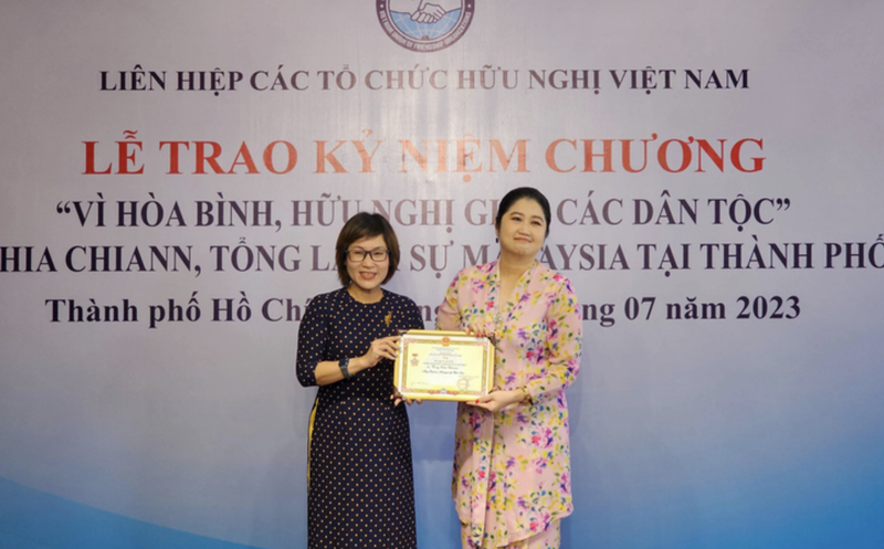 越南友好组织联合会代表向马来西亚驻胡志明市总领事Wong Chia Chiann女士授予“致力于各民族和平与友谊”纪念章。（图片来源：越通社）