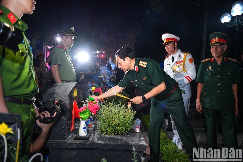 越南国防部部长潘文江大将参加“点亮蜡烛 缅怀英雄烈士”仪式。
