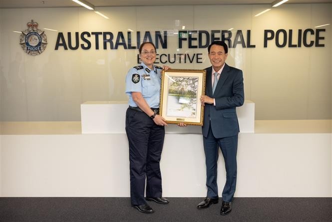 越南公安部副部长黎国雄向澳大利亚联邦警察局副司令盖尔莱斯·盖尔赠送礼物。（图片来源：越通社）
