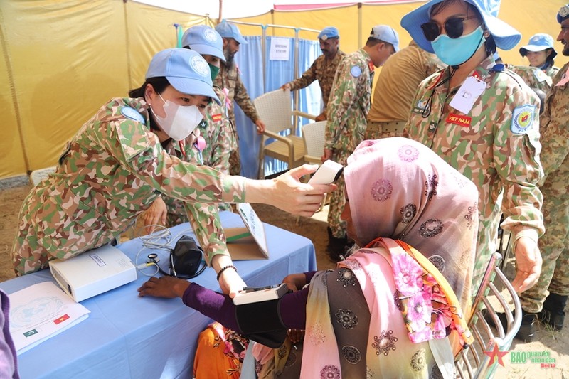 越南医生为当地民众进行体检。（图片来源：《人民军队报》）