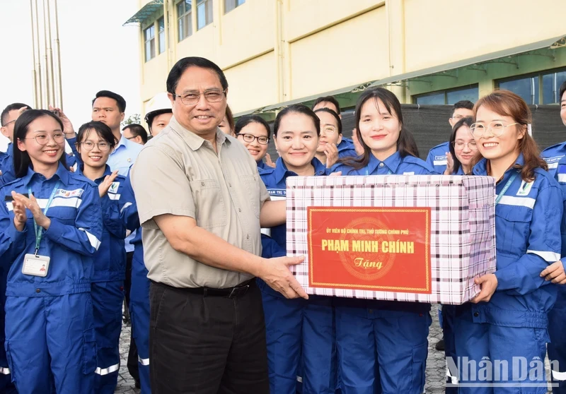 越南政府总理范明正向宜山炼油厂工程师和工人赠送礼物。