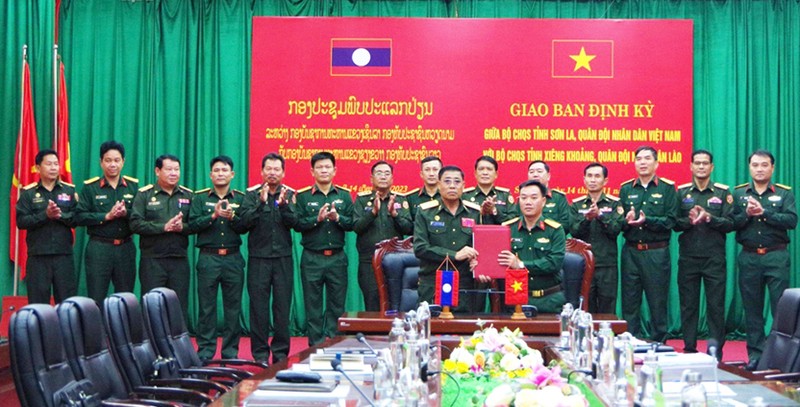 山罗省军事指挥部与老挝川圹省军事指挥部签署2023年会议纪要。（图片来源：《人民军队报》）