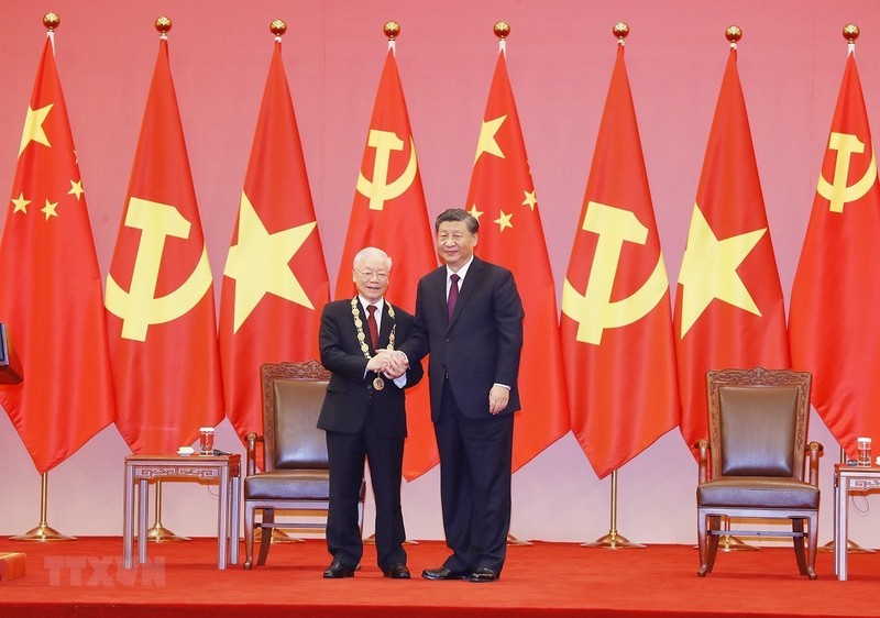 中共中央总书记、中国国家主席习近平向越共中央总书记阮富仲授予中华人民共和国“友谊勋章”。（图片来源：越通社）