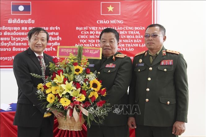 阮伯雄大使向老挝人民军民族文化寄宿学校校委会赠送献花。（图片来源：越通社）