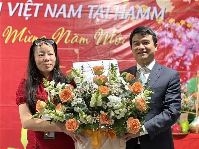 越南驻德国法兰克福总领事馆代表刘春同送鲜花，庆祝旅居德国哈姆市越南人协会的成立。（图片来源：越通社）