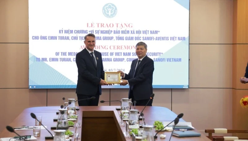 阮德和副总经理授予艾敏·图兰先生“致力于越南社会保险事业”纪念章。