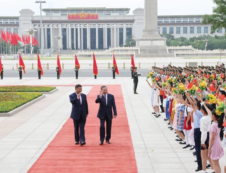 苏林总书记、国家主席和习近平总书记、国家主席向孩子们挥手。（图片来源： 越通社）