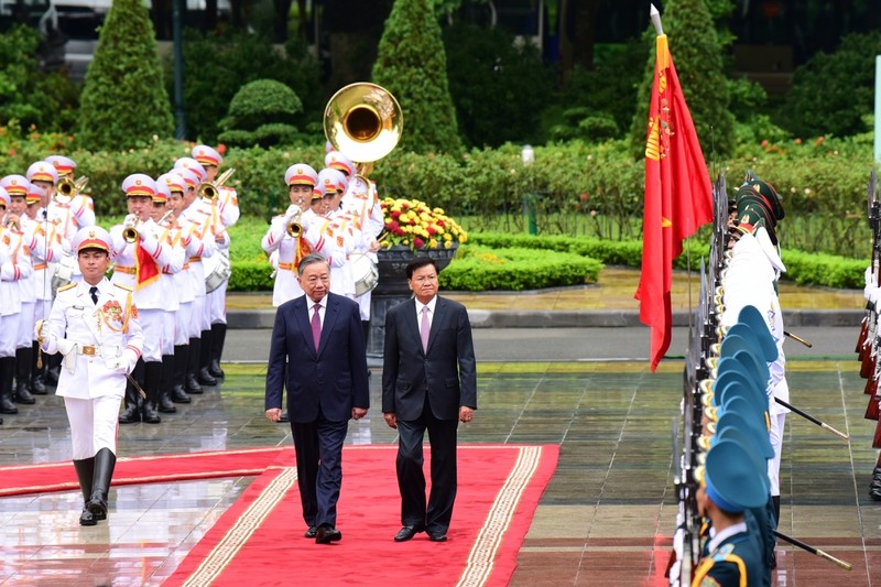 老挝人民革命党中央总书记、国家主席通伦·西苏里和越共中央总书记、国家主席苏林检阅仪仗队。