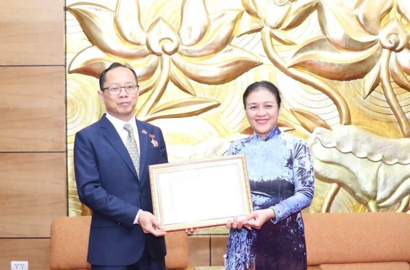 越南友好组织联合会主席阮芳娥大使向柬埔寨驻越南大使查伊·纳芙斯授予“致力于各民族和平友谊” 纪念章。