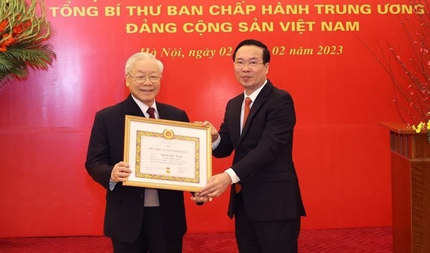 越共中央书记处常务书记武文赏代表党领导向越共中央总书记阮富仲授予党龄55年徽章。