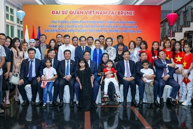 越南政府总理范明正和夫人同越南驻文莱代表机构工作人员和旅文越南人社群合影。