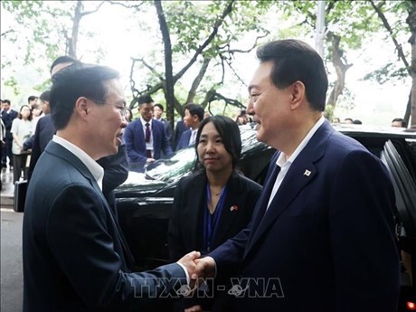 越南国家主席武文赏（左）与韩国总统尹锡悦（右）亲切握手。（图片来源：越通社）